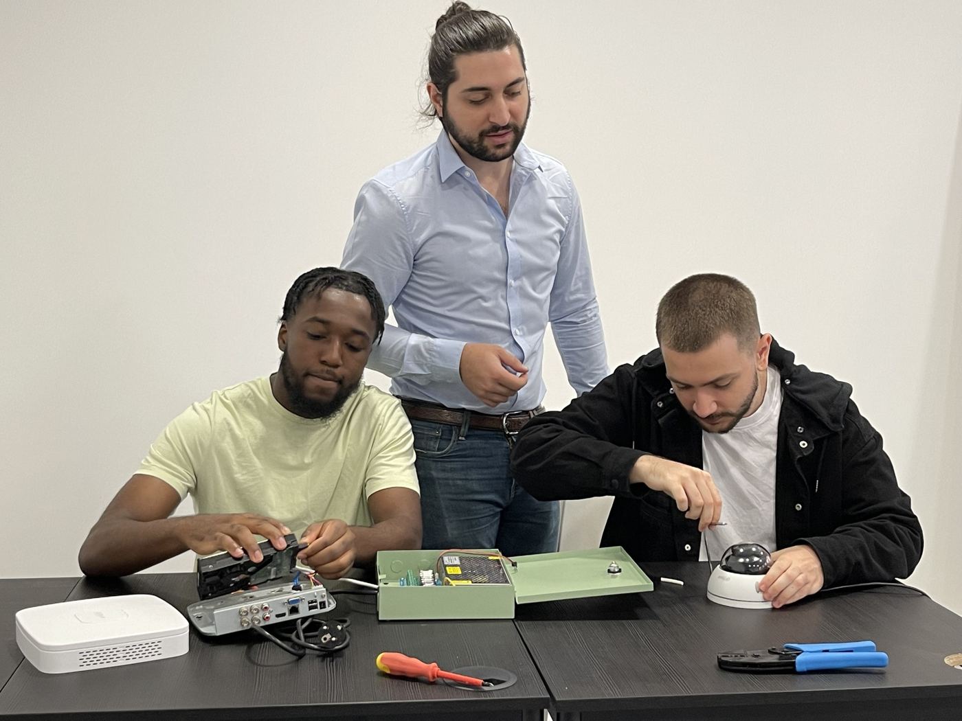 Apprenants et formateur en atelier de réparation chez AR Compétences